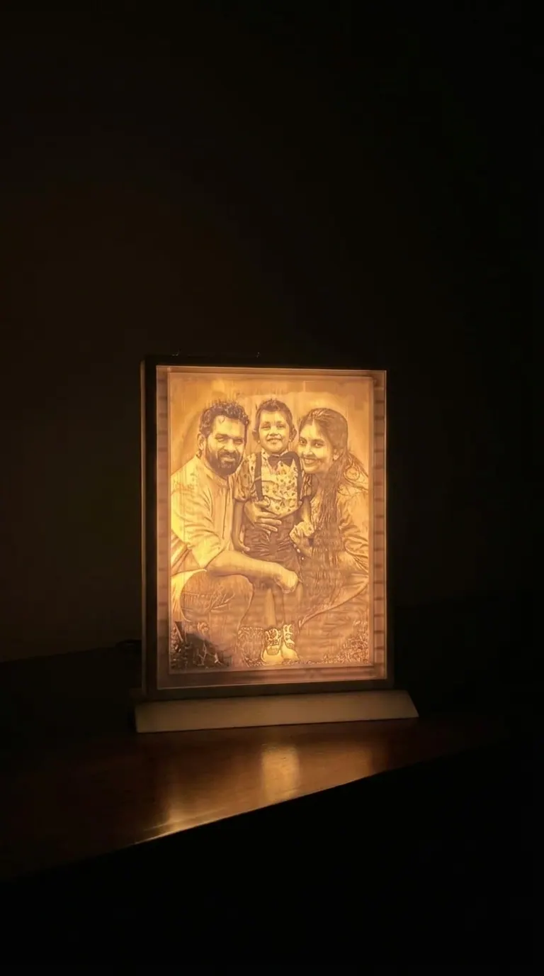 Illuminated 3D printed lithophane photo lamp showing a family portrait in warm light